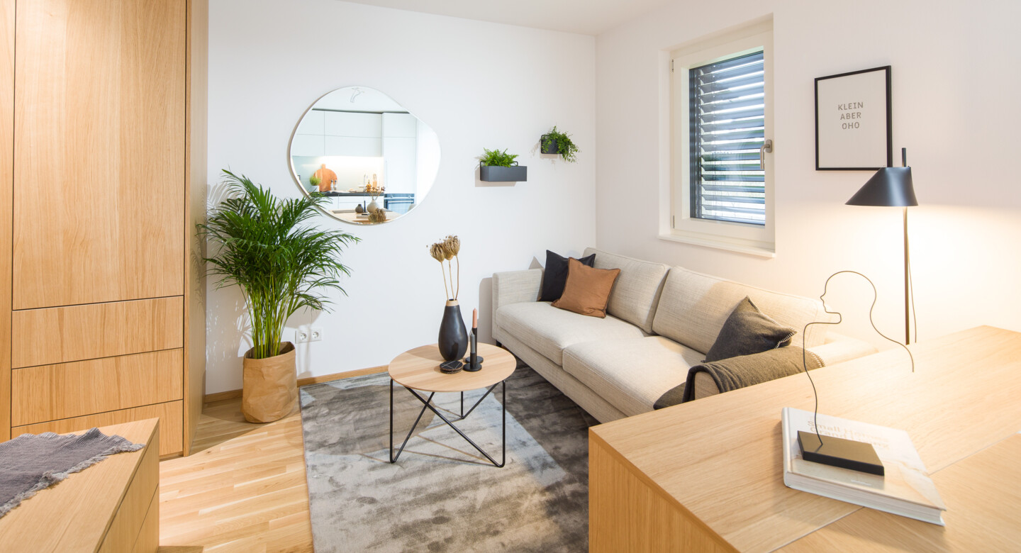 Couch mit kleinem Tisch, Spiegel und geschlossenem Fenster David