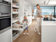 Frau mit Mädchen in Küche, Mädchen öffnet Schublade und Frau kocht David