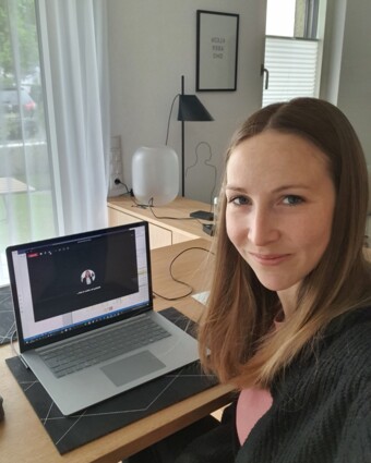 Frau am Laptop auf Esstisch vor Balkontür David