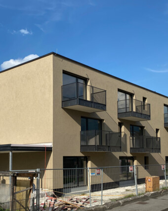 Gebäude von Außen mit Baustellenzaun und Himmel David