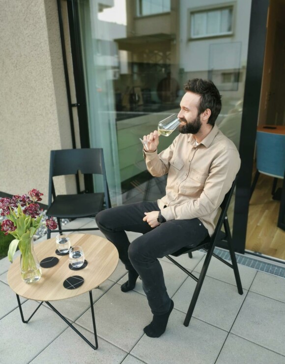 Mann trinkt Glas Wein im Garten auf Stuhl David