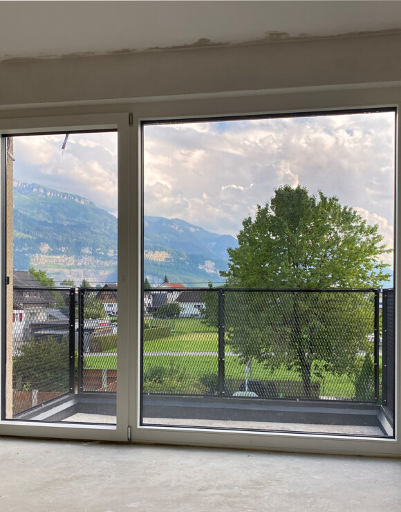 Balkon von Innen mit Aussicht auf Baum und Berge David